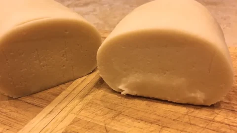 Zelf marsepein maken volgens oma’s ouderwetse recept, romige amandelsmaak op houten plank.